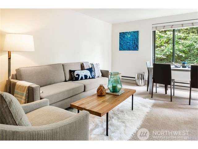 1105 Spring Street, Unit 305 Seattle, WA 98104 - Photo 19 of 25 a living room with furniture and a lamp