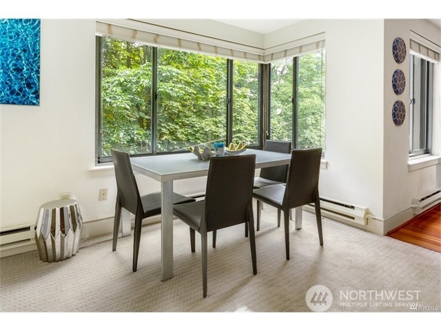 1105 Spring Street, Unit 305 Seattle, WA 98104 - Photo 20 of 25 a dining room with furniture and a floor to ceiling window