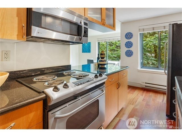 1105 Spring Street, Unit 305 Seattle, WA 98104 - Photo 22 of 25 a kitchen with a stove and a wooden floor