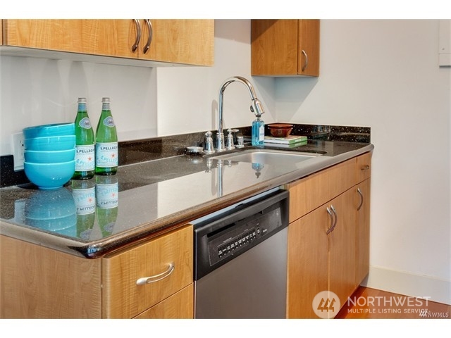 1105 Spring Street, Unit 305 Seattle, WA 98104 - Photo 23 of 25 a kitchen with a sink and cabinets