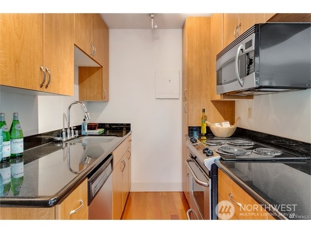 1105 Spring Street, Unit 305 Seattle, WA 98104 - Photo 24 of 25 a kitchen that has a sink and a stove