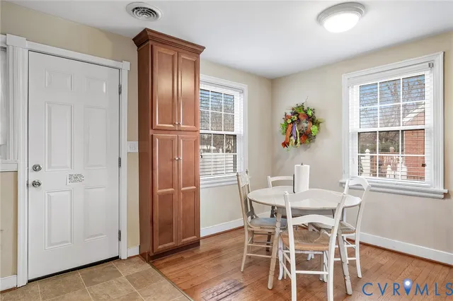 a dining room with furniture entryway and wooden floor