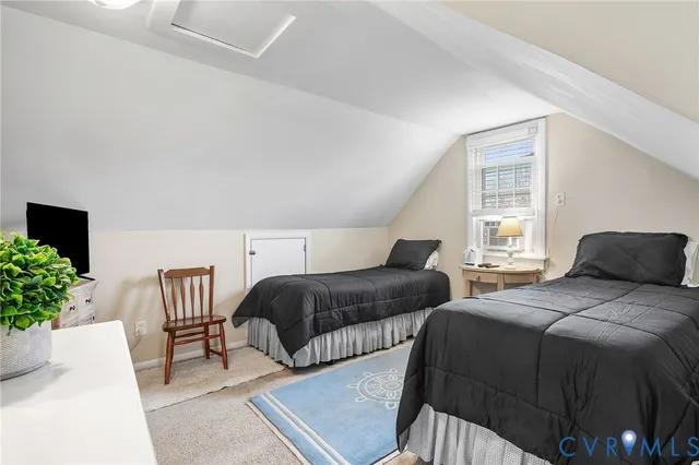 a bedroom with two beds and a potted plant