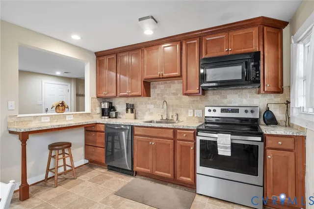 a kitchen with stainless steel appliances granite countertop a stove top oven a sink dishwasher and a microwave oven on the stove