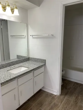 a bathroom with a granite countertop sink and a mirror