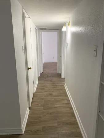a view of a hallway with wooden floor