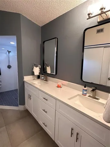 a bathroom with a double vanity sink and a mirror
