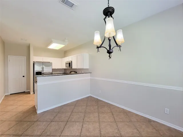 a kitchen with kitchen island white cabinets and refrigerator