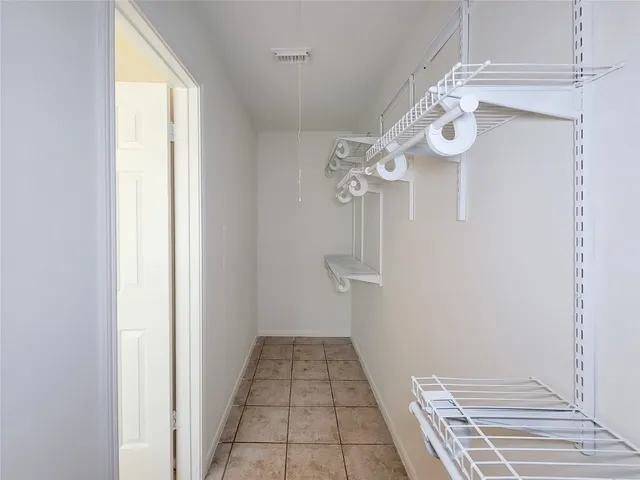 a view of a hallway with wooden floor and chandelier