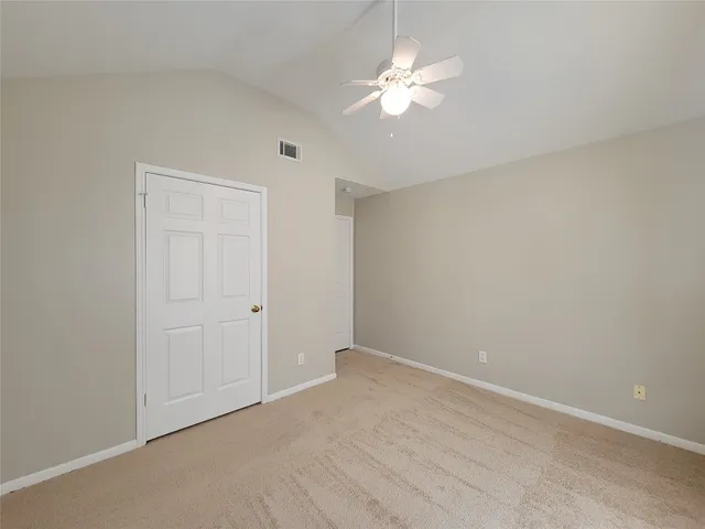 an empty room with chandelier fan