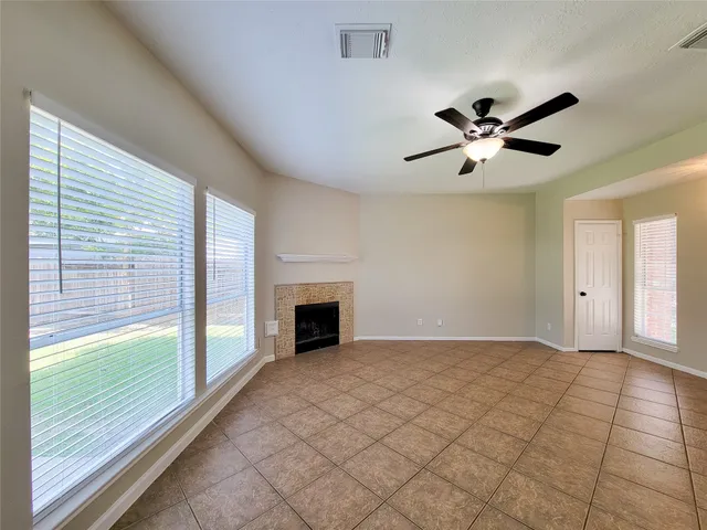 a view of an empty room with a fireplace and a large window