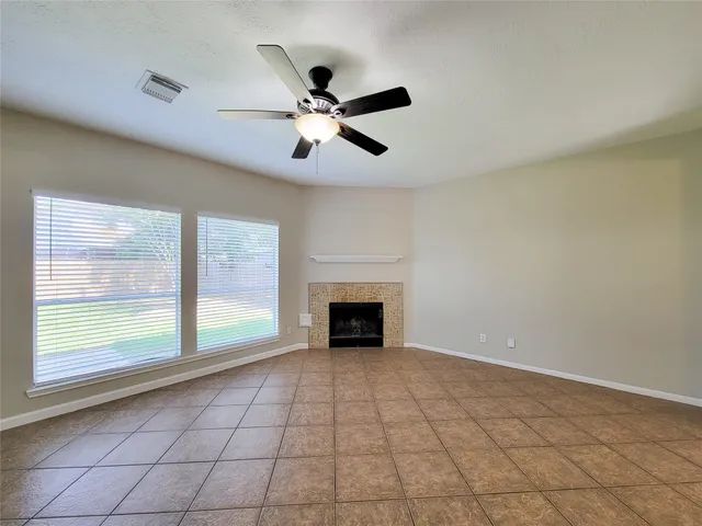 a view of an empty room with a fireplace and a window
