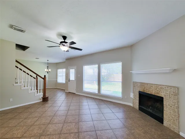 a view of an empty room with windows and fireplace