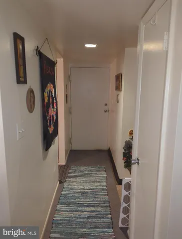 a view of a hallway with wooden floor and stairs