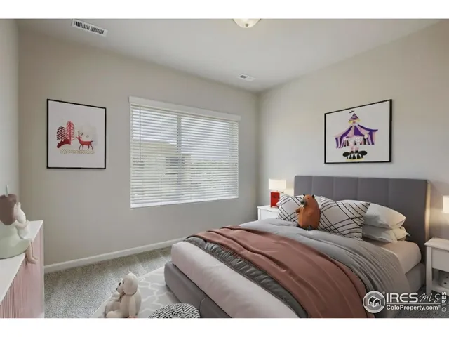 a bedroom with a bed and a painting on the wall
