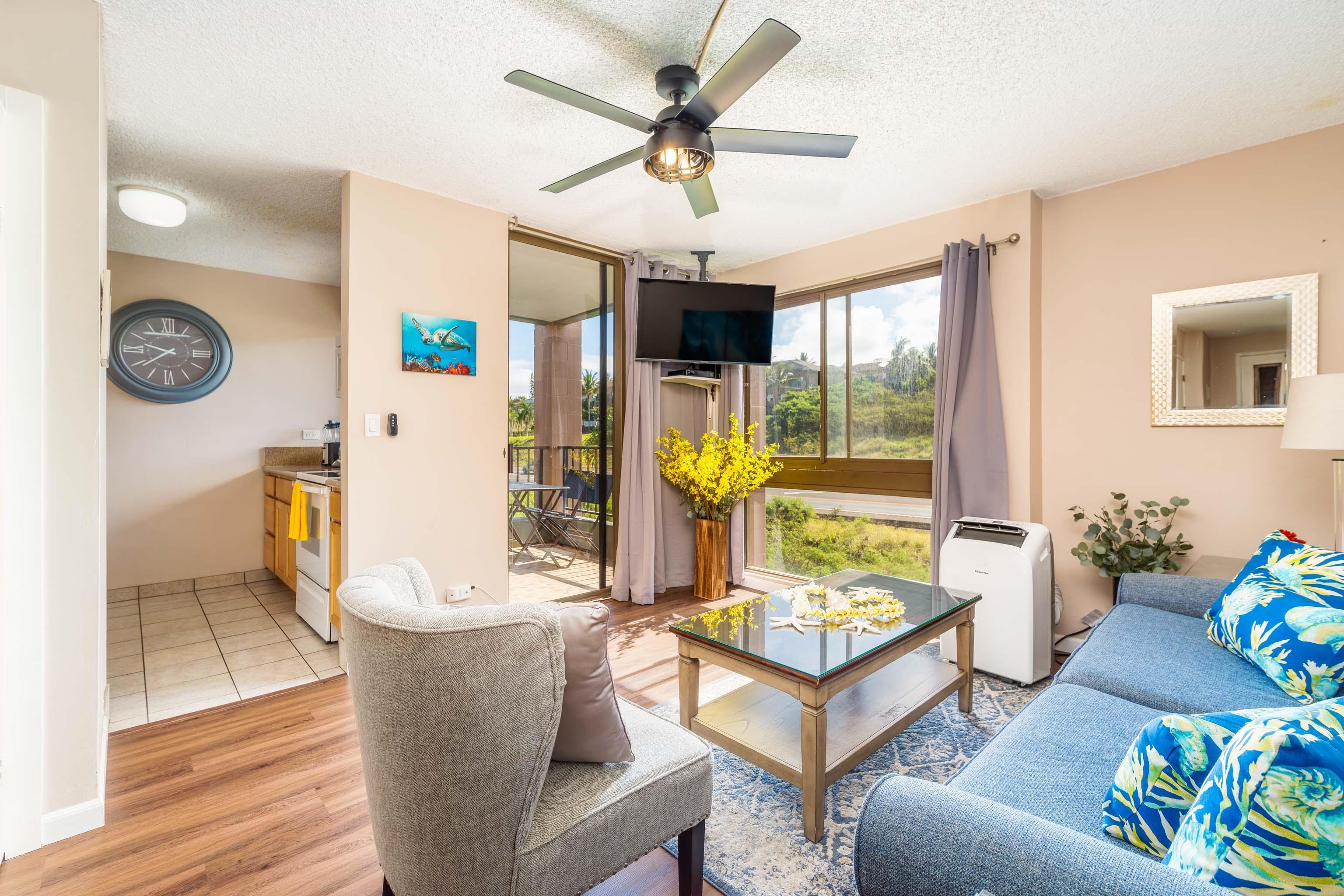 4310 Lower Honoapiilani Road, Unit 418 Lahaina, HI 96761 - Photo 5 of 31 a living room with furniture a flat screen tv and a large window