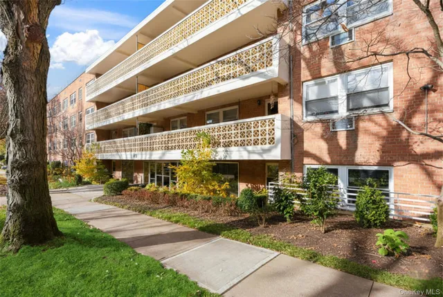 a front view of a building with a garden