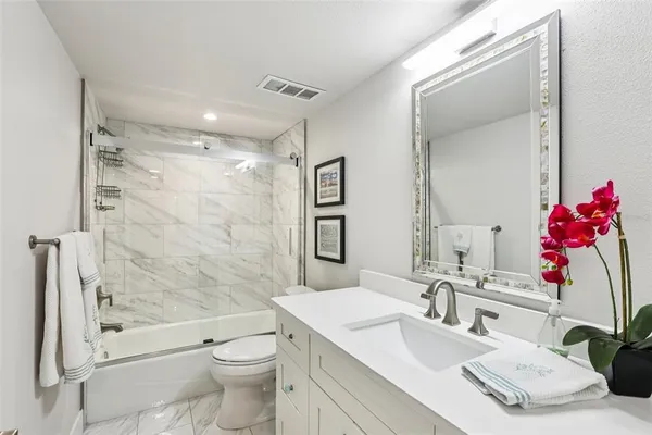 a bathroom with a sink vanity mirror and toilet