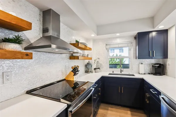 a kitchen with stainless steel appliances a refrigerator and a stove top oven