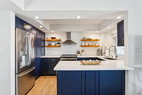 a kitchen with stainless steel appliances a sink stove and refrigerator