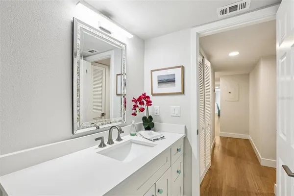 a bedroom with a bed and a lamp on dresser