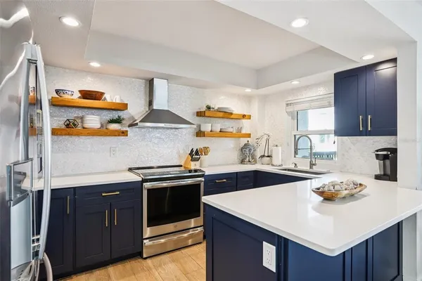 a kitchen with stainless steel appliances a sink and wooden cabinets