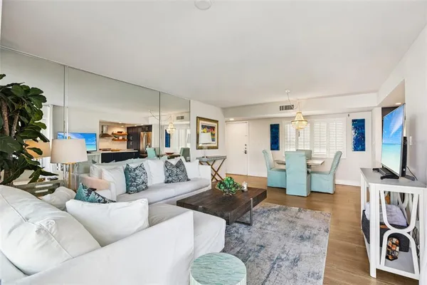 a living room with furniture a flat screen tv and a dining table