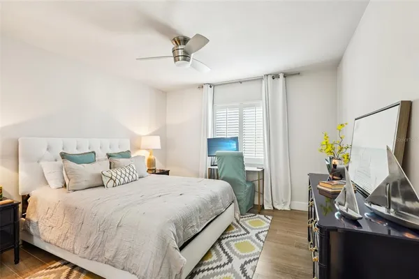 a bedroom with a bed table and a flat screen tv