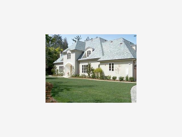 a view of a big house with a big yard and large tree