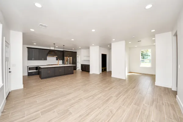 a view of kitchen with kitchen island a sink stainless steel appliances and cabinets