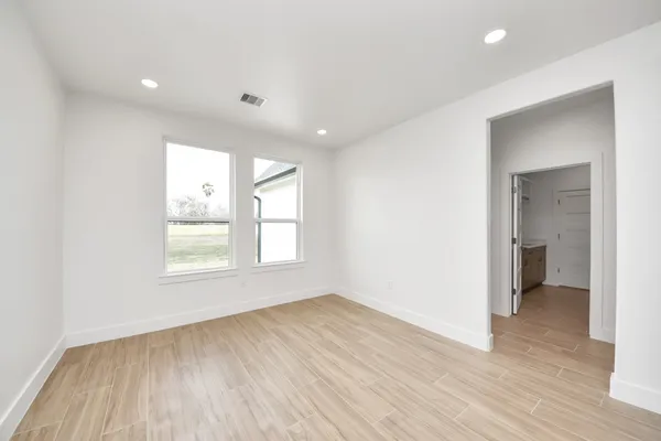 an empty room with wooden floor and a window