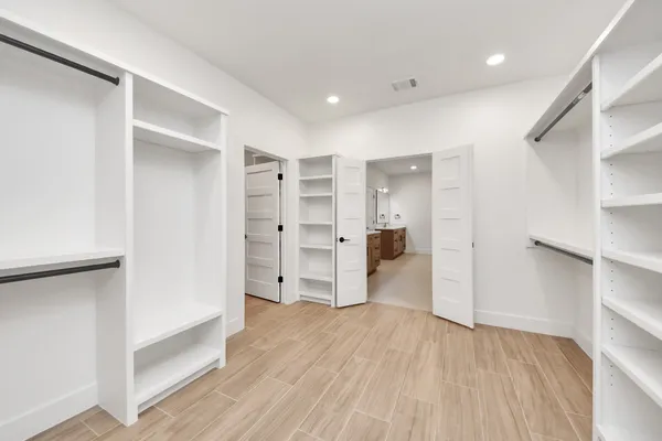 a view of walk in closet with wooden floor
