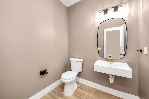 a bathroom with a toilet sink and mirror