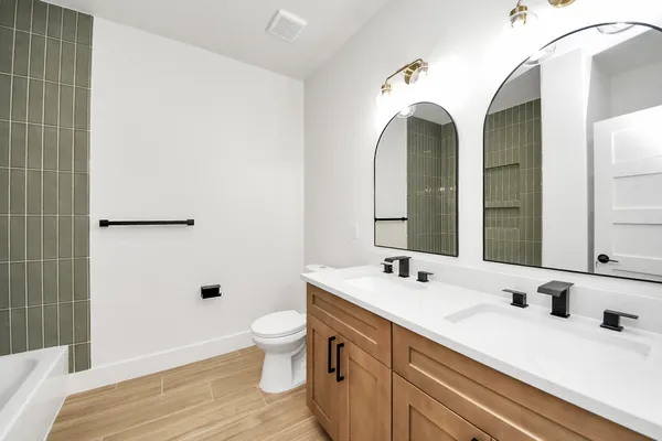 a spacious bathroom with a double vanity sink toilet mirror and shower