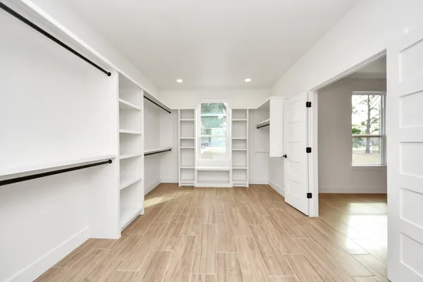 a view of empty room with wooden floor and window