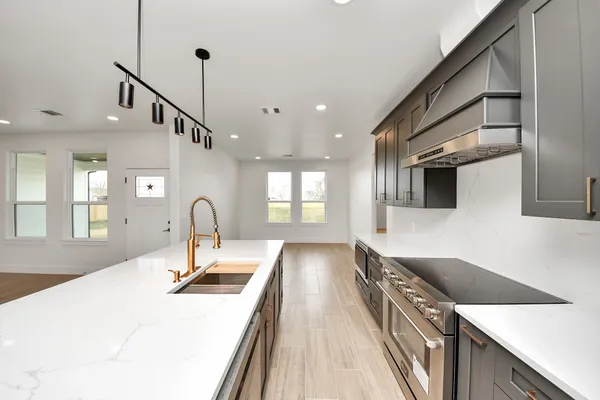 a kitchen with kitchen island a sink appliances and a counter top space