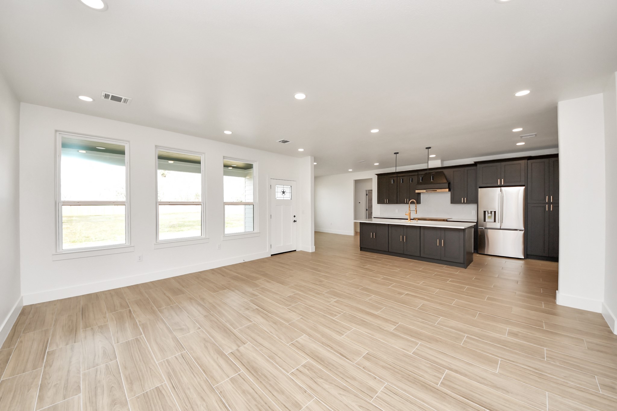 5811 County Road 675B Rosharon, TX 77583 - Photo 9 of 39 a view of a kitchen with kitchen island a sink wooden floor and a large window