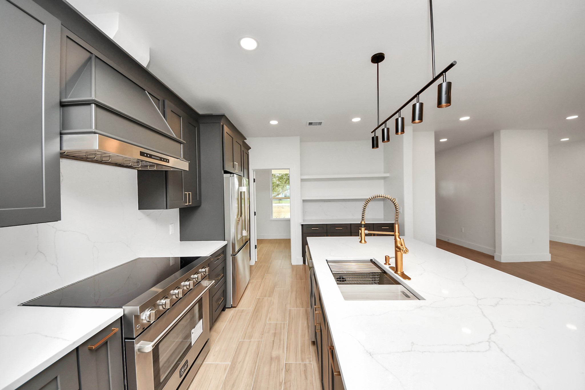 5811 County Road 675B Rosharon, TX 77583 - Photo 10 of 39 a large kitchen with stainless steel appliances kitchen island a large counter top a stove a chimney a sink and cabinets