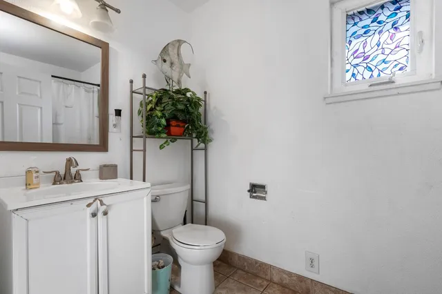 a bathroom with a toilet sink and mirror