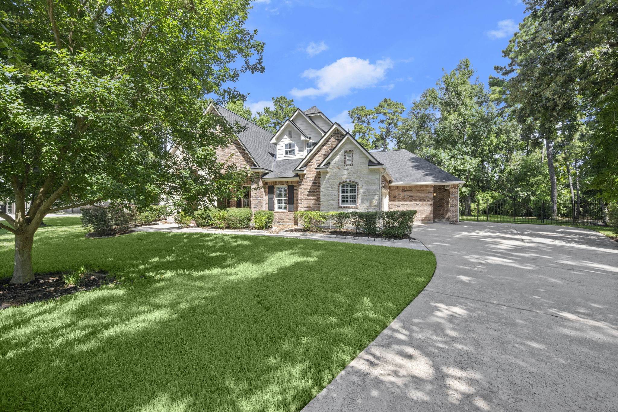 4106 Angling Lane Spring, TX 77386 - Photo 2 of 50 Charming brick home nestled in a lush, wooded setting, featuring a spacious driveway and manicured lawn, offering a peaceful and inviting atmosphere.