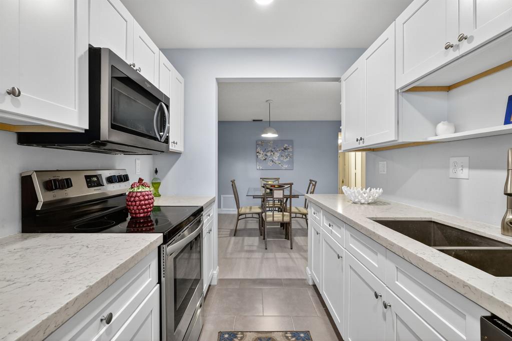 13930 Nesting Way, Unit C Delray Beach, FL 33484 - Photo 15 of 41 a kitchen with a sink a stove and cabinets