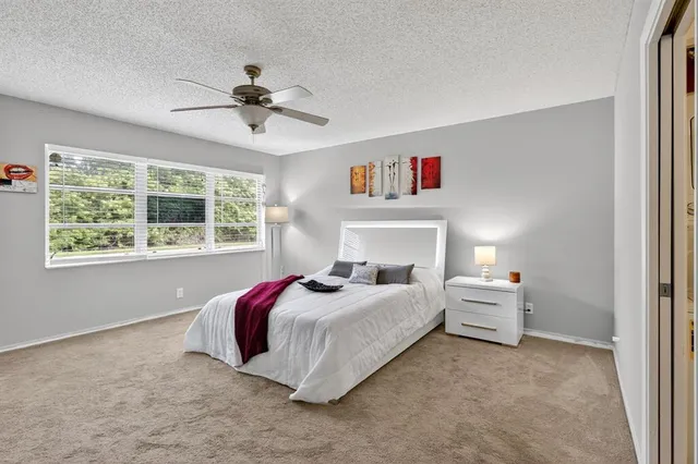 a bedroom with a bed and a large window