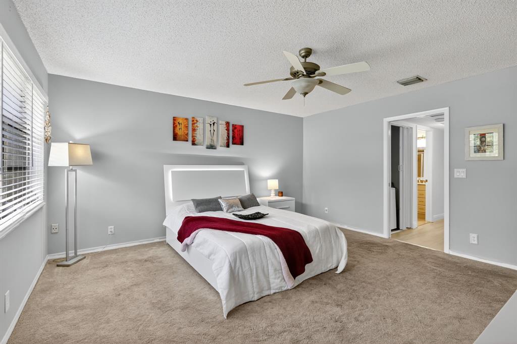 13930 Nesting Way, Unit C Delray Beach, FL 33484 - Photo 25 of 41 a bedroom with a bed and a chandelier