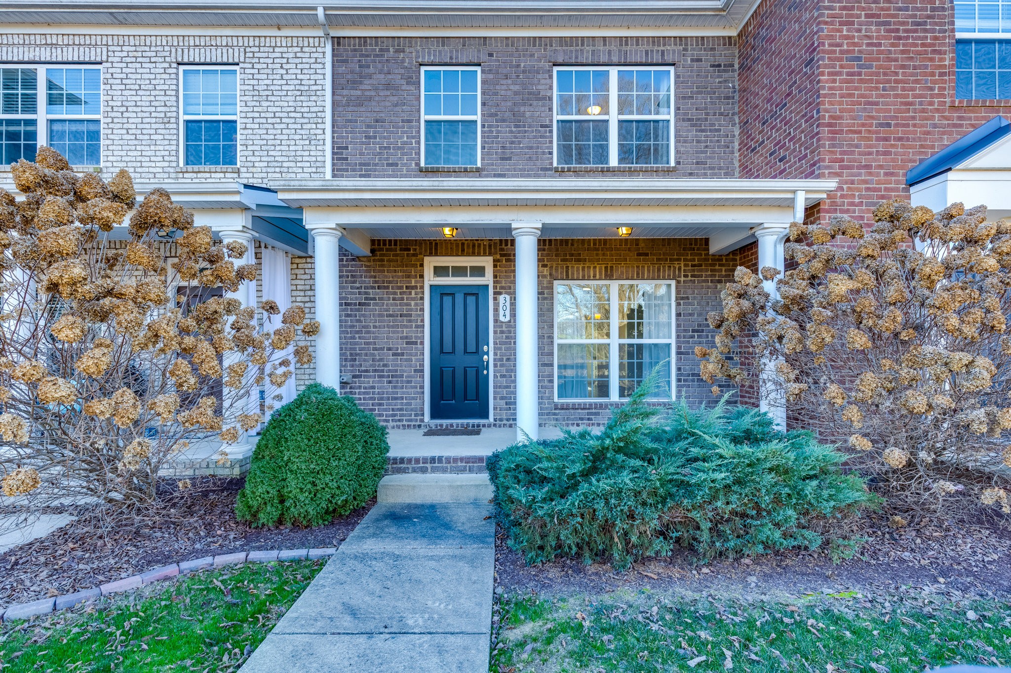 front view of a brick house with a small yard