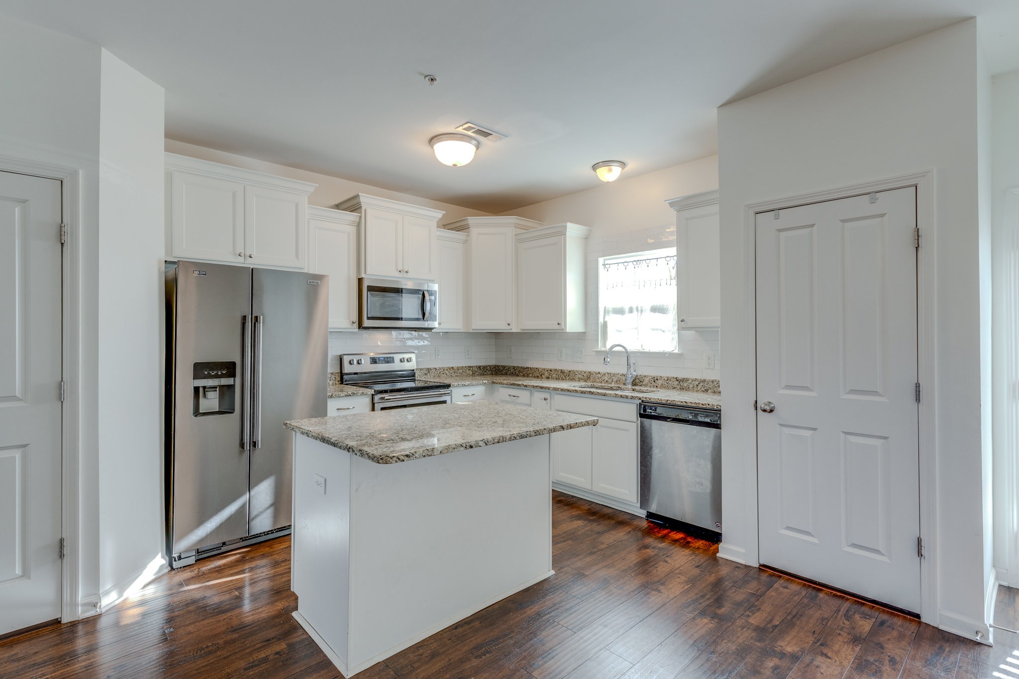 304 Oldbury Lane Spring Hill, TN 37174 - Photo 14 of 41 a kitchen with stainless steel appliances granite countertop a refrigerator a sink dishwasher a stove and white cabinets with wooden floor