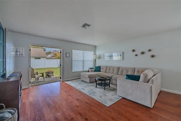 a living room with furniture and wooden floor