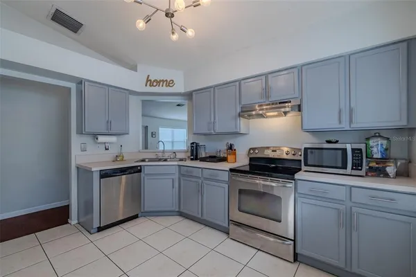 a kitchen with granite countertop cabinets stainless steel appliances and a sink