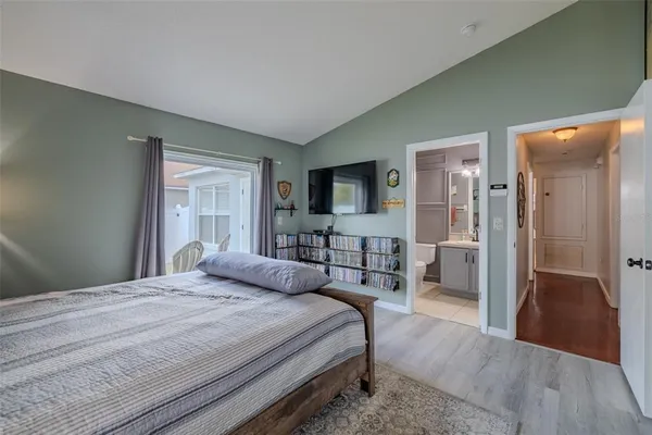 a bedroom with a bed and a flat tv screen on dresser