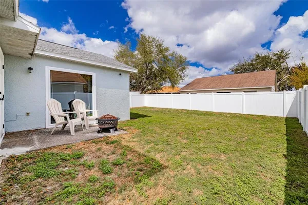 a backyard of a house with table and chairs