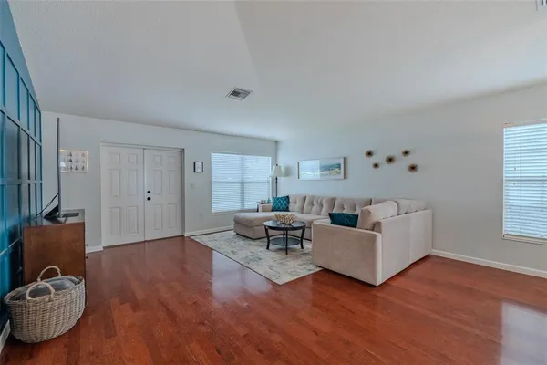 a living room with furniture and a wooden floor